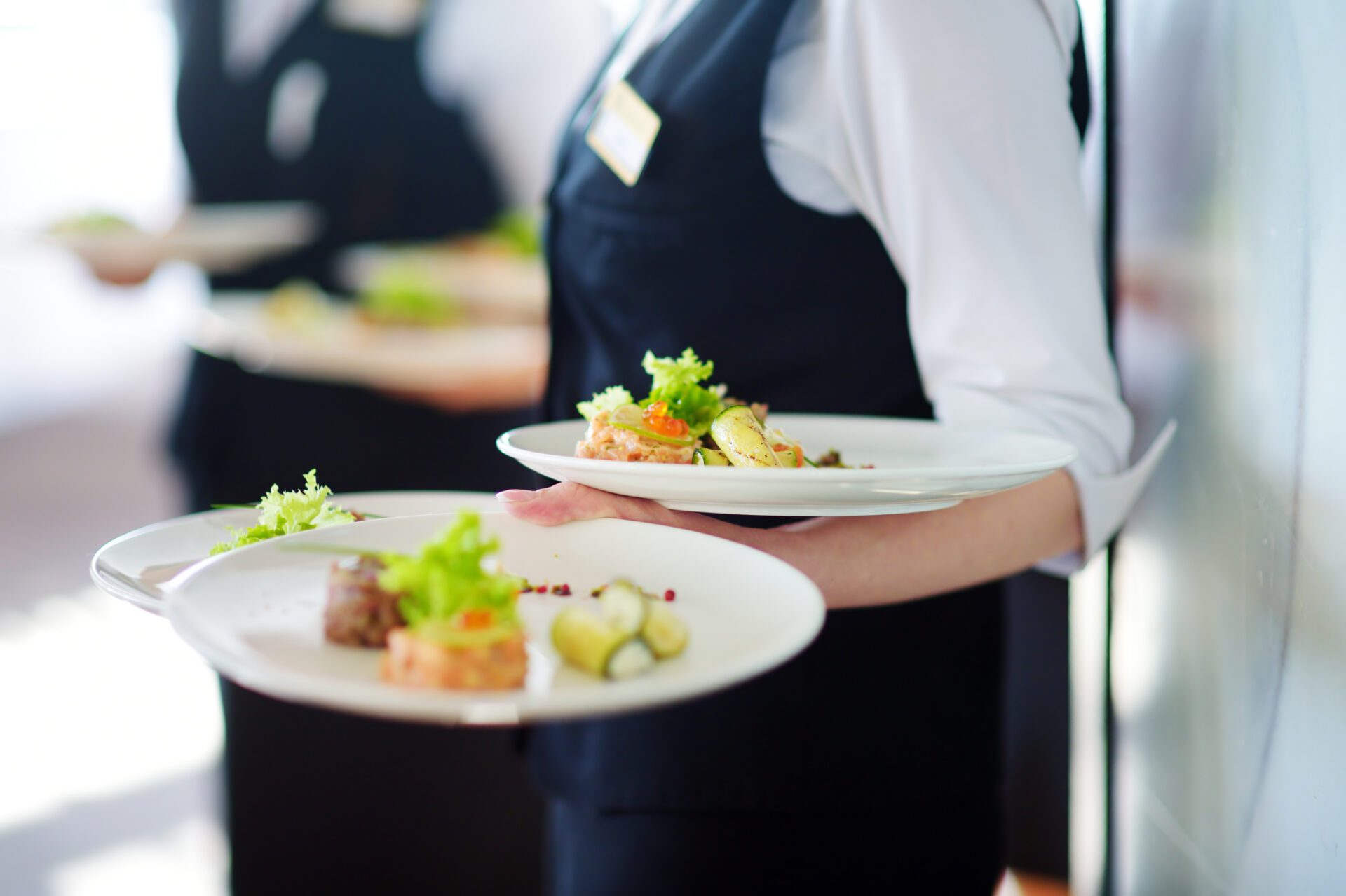 Waiter carrying plates with meat dish on some festive event Waiter carrying plates with meat dish on some festive event, party or wedding reception